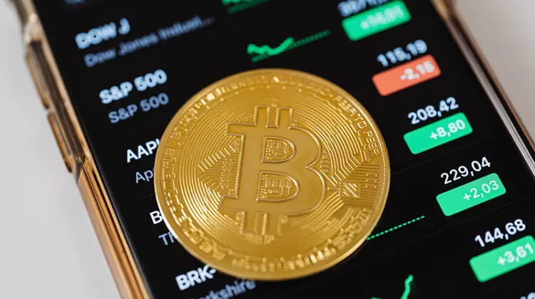 Gold bitcoin on top of mobile phone