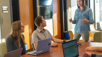 Two person sitting beside laptop