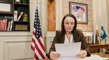 Woman lawyer reading documents sitting inside lawyer office