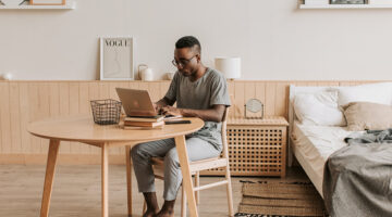 Man in gray crew neck t-shirt sitting in brown wooden chair and table