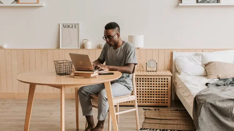Man in gray crew neck t-shirt sitting in brown wooden chair and table