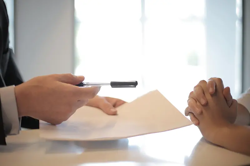 businessman giving insurance document to woman to sign