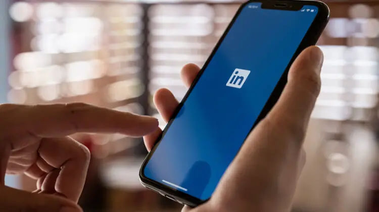 LinkedIn logo on phone screen.