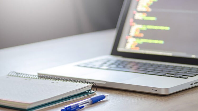 Notepad and pen near laptop