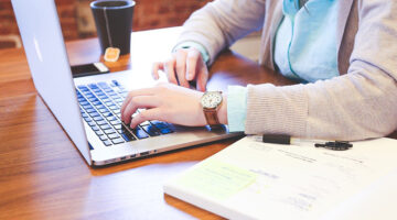 person working on macbook sitting at a desk
