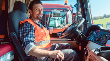 Lorry or truck driver sitting in the cabin of his vehicle