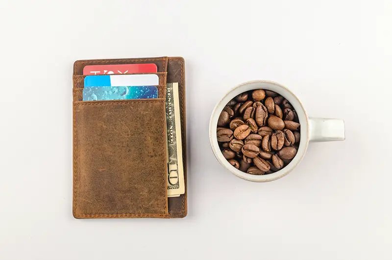 Brown wallet beside the white coffee mug