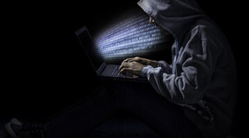 Cybersecurity hacker in dark gray hoodie