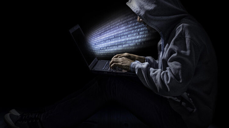 Cybersecurity hacker in dark gray hoodie