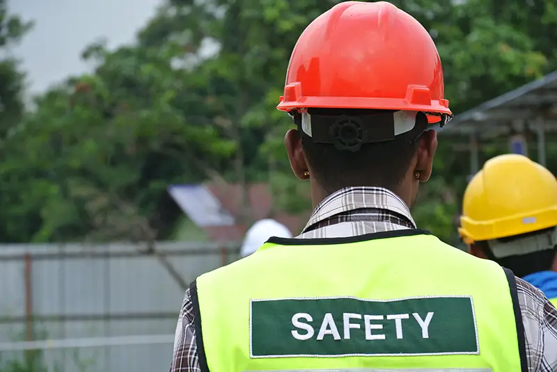 Construction workers wear safety vest has safety sign on it.
