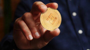Binance BNB cryptocurrency symbol golden coin in hand abstract concept