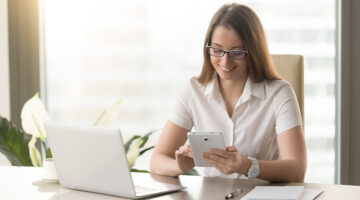 Woman smiling while using her mobile phone