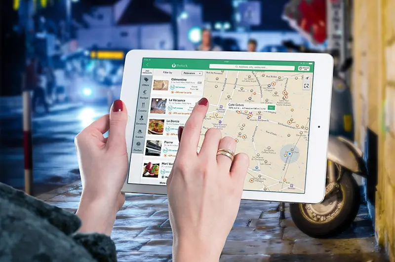 woman using white iPad with map on the screen