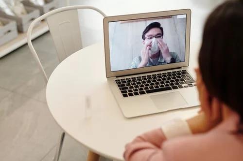 man and woman talking via video call on laptop