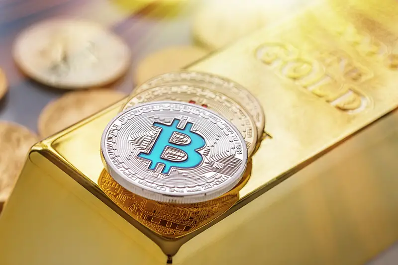 Bitcoin on top of gold bar