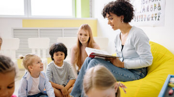 Woman reading a book to the children
