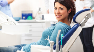 Young female patient sitting on chair in dental office.preparing for dental exam