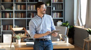 Young businessman smiling while holding his ipad