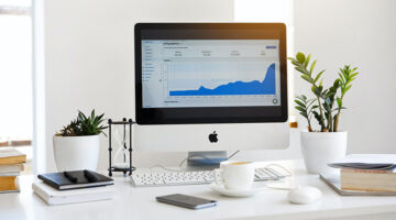 Silver Imac displaying line graph placed on desk