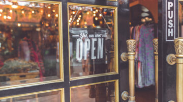 Close up photo of black door with signage yes we're open