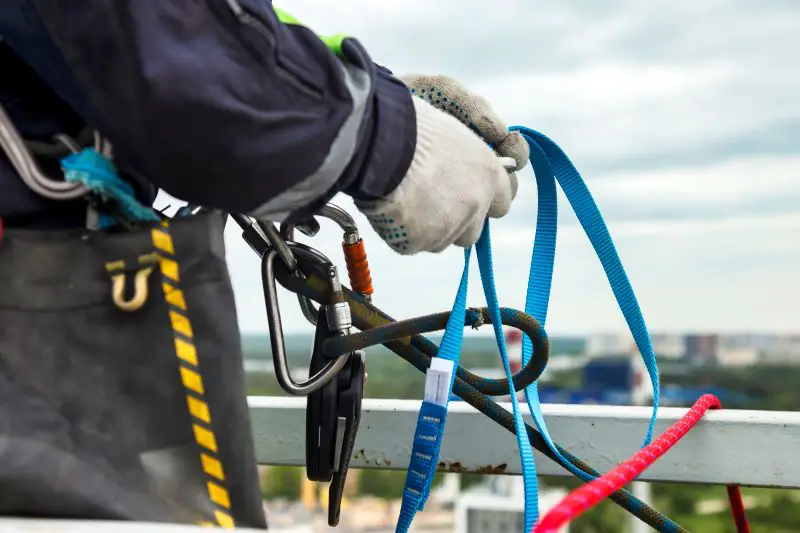 Close-up hands of man industry mountaineer worker in job uniform with rope equipment