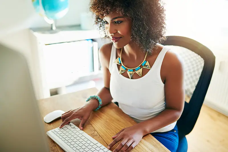 Woman wearing white sleeveless working on her computer