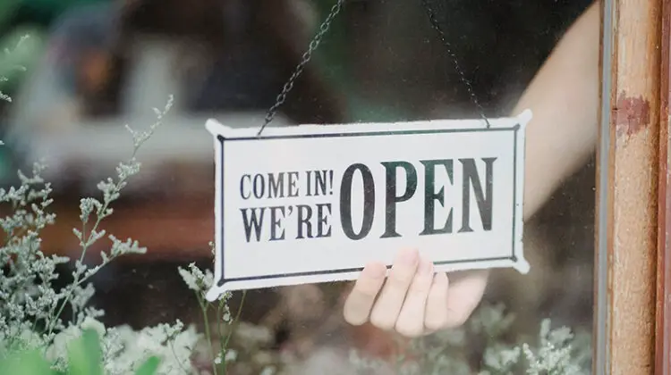 Crop person showing signboard on window