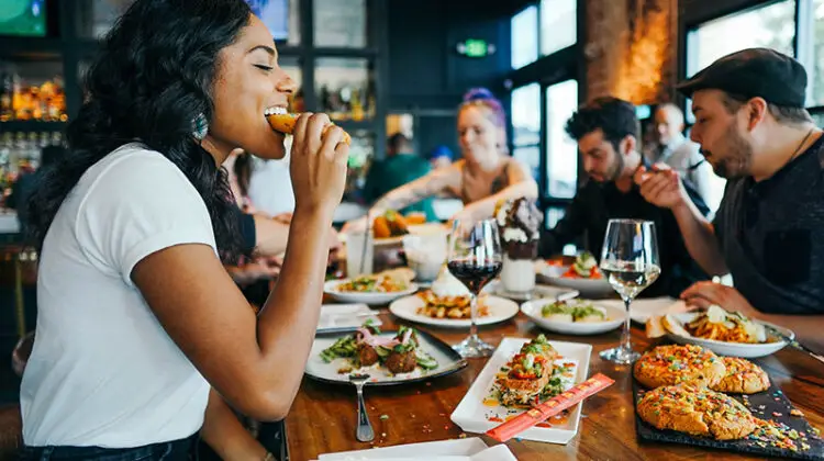 Woman in white shirt eating in a restaurant