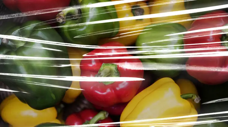 Fresh bell peppers covered with plastic wrap
