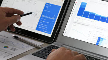 Person using laptop with graphs and analytics on the screen