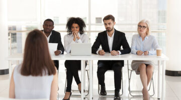 Diverse HR managers listen to female job candidate speaking during work interview in office