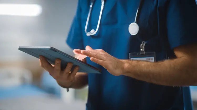 Surgeon Uses Digital Tablet Computer Health Care Vitals Monitoring Computer Machine