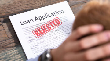 Stressed Person Looking At Rejected Loan Application
