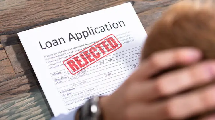 Stressed Person Looking At Rejected Loan Application