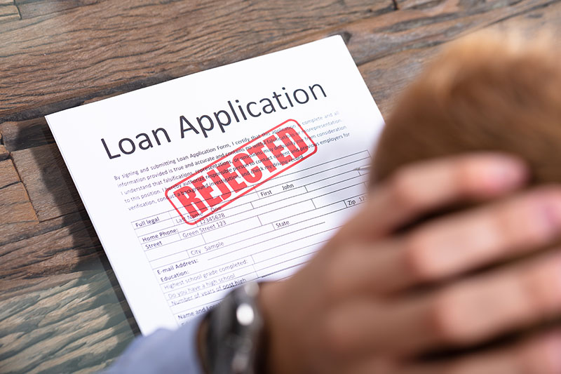 Stressed Person Looking At Rejected Loan Application
