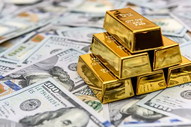 Gold bars on top of dollar bills