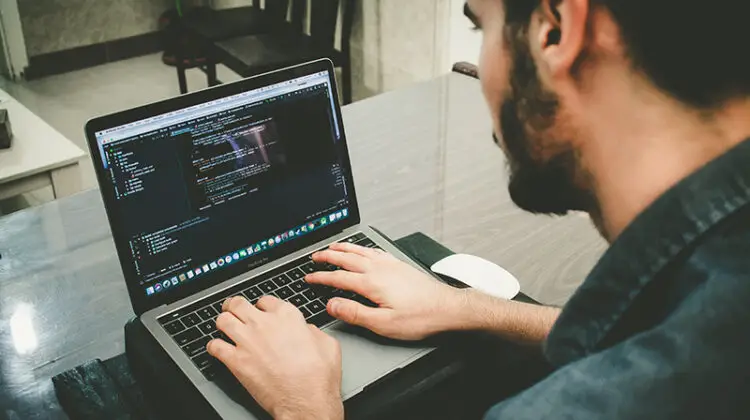 man programming using laptop