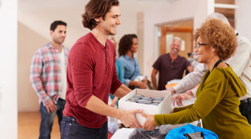 People Donating Food To Charity Food Bank Collection In Community Center