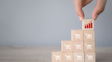 Hand arranging wood block stacking with icon Graph and shopping cart symbol
