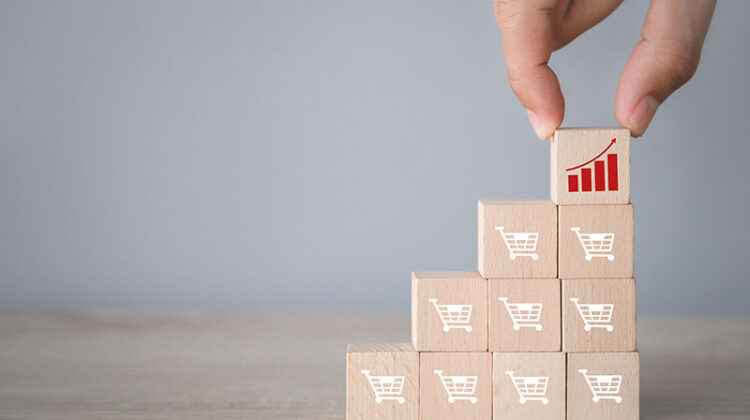 Hand arranging wood block stacking with icon Graph and shopping cart symbol