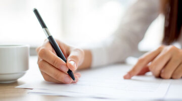 Hand of businesswoman signing on document