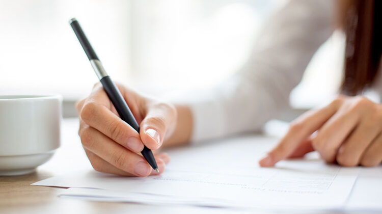 Hand of businesswoman signing on document
