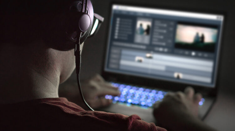 Man wearing headphone editing a video on his laptop