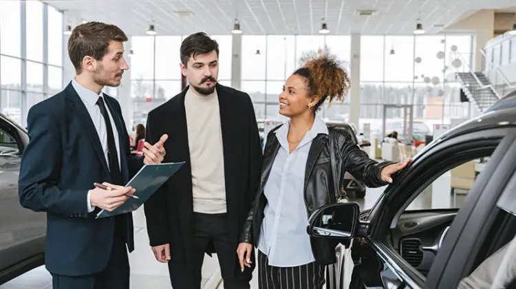 Car sales man talking to a couple client