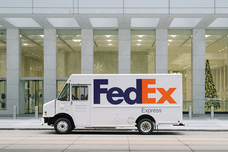 FedEx delivery van in front of white building