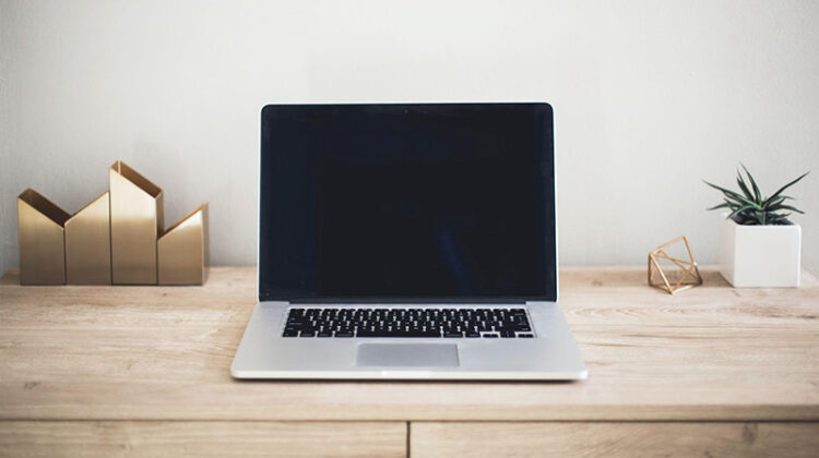 Laptop off screen on top of brown wooden table