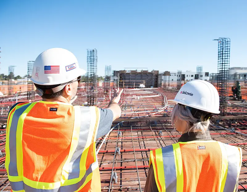 Man and woman wearing white hard hat in construction site