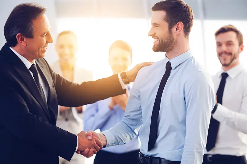 Two cheerful business men shaking hands