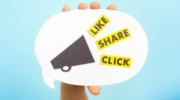 Hand holding a announce with megaphone and the words "LIKE" "SHARE" "CLICK", on blue background.