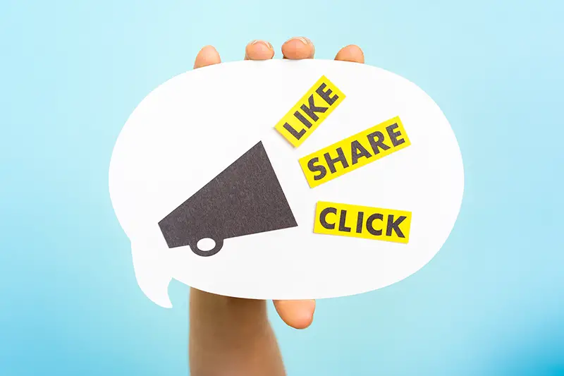 Hand holding a announce with megaphone and the words "LIKE" "SHARE" "CLICK", on blue background.